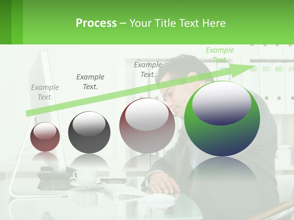 A Man Sitting At A Desk In Front Of A Computer PowerPoint Template