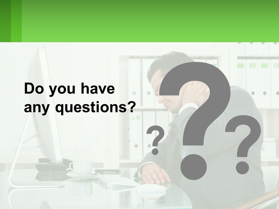 A Man Sitting At A Desk In Front Of A Computer PowerPoint Template