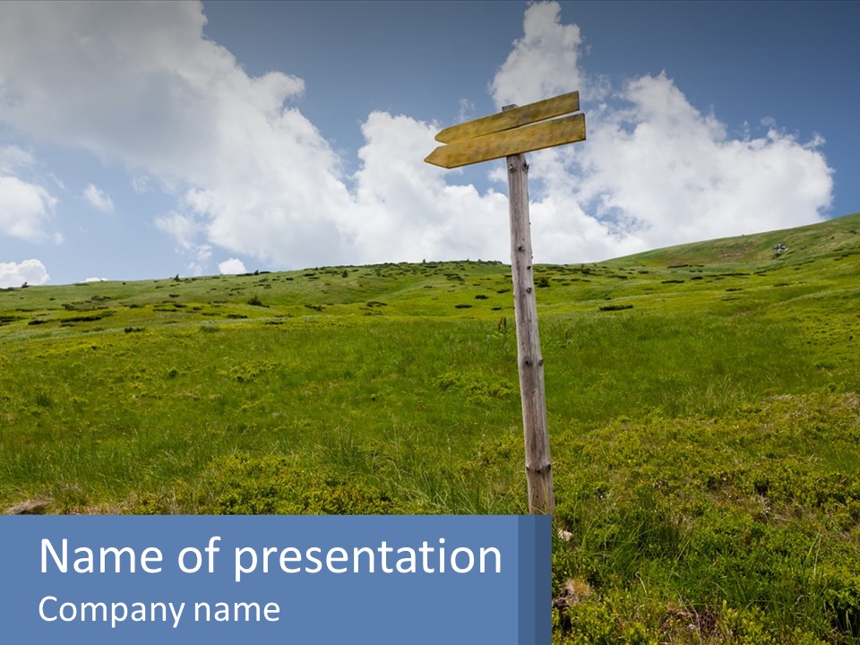 A Wooden Sign In A Grassy Field With A Sky Background PowerPoint Template