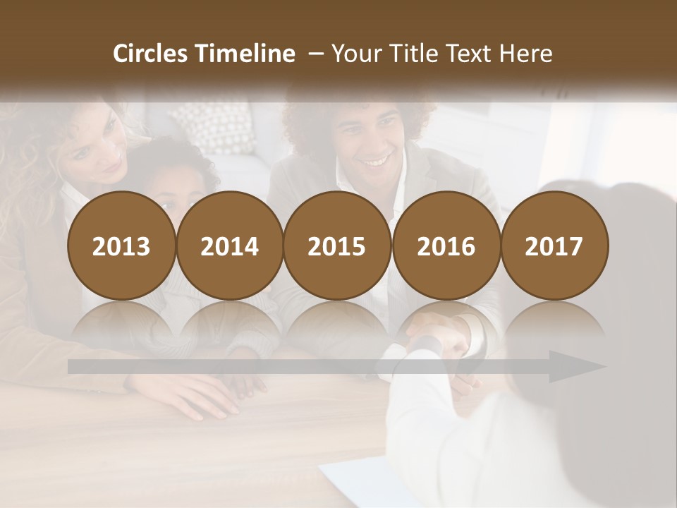 A Group Of People Sitting Around A Wooden Table PowerPoint Template