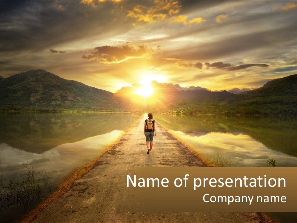 A Person Walking Down A Road With The Sun Setting In The Background PowerPoint Template