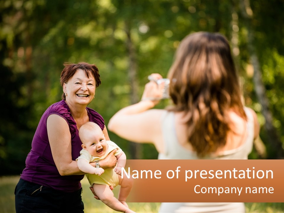 A Woman Taking A Picture Of A Woman Holding A Baby PowerPoint Template