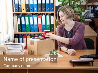 A Woman Sitting At A Desk In Front Of A Computer PowerPoint Template