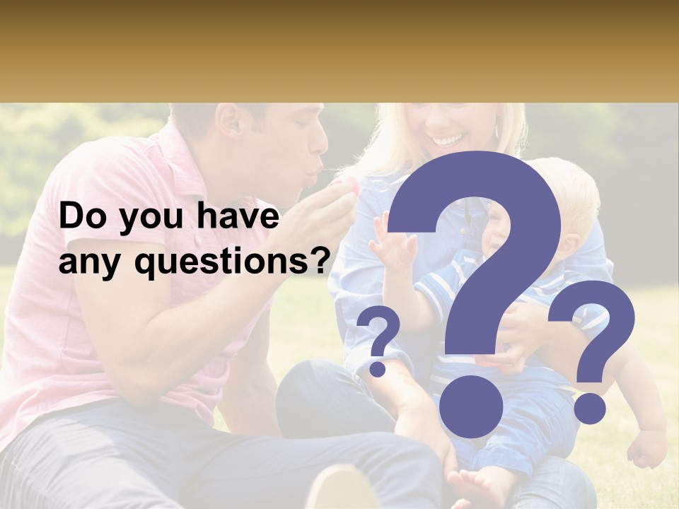 A Man And A Woman Are Sitting On The Grass With A Baby PowerPoint Template