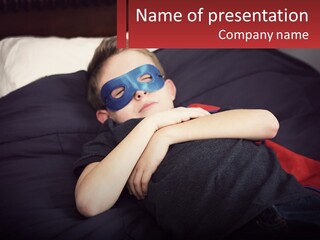A Young Boy Wearing A Mask Sleeping On A Bed PowerPoint Template