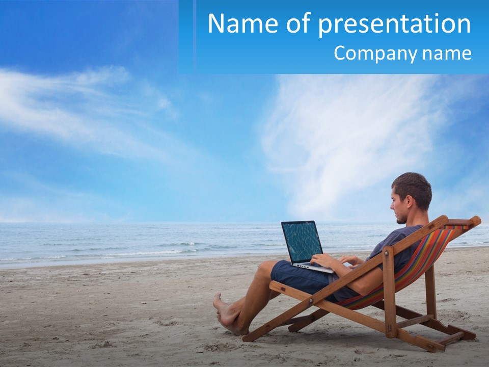 A Man Sitting In A Chair On A Beach Using A Laptop PowerPoint Template