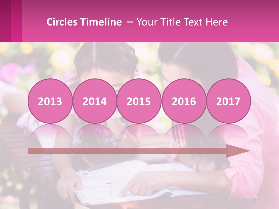 Two Girls Are Looking At A Book On A Bench PowerPoint Template