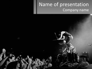 A Man On Top Of A Drum Set In Front Of A Crowd PowerPoint Template
