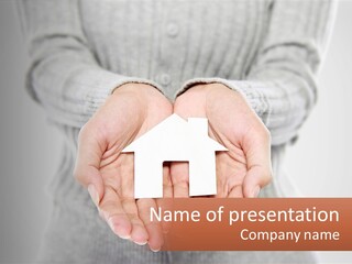 A Person Holding A Paper House In Their Hands PowerPoint Template