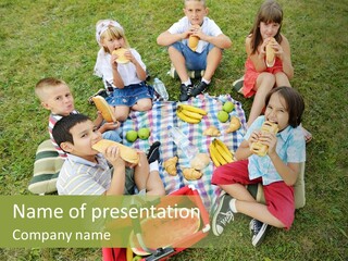 A Group Of Children Sitting On A Blanket Eating Food PowerPoint Template