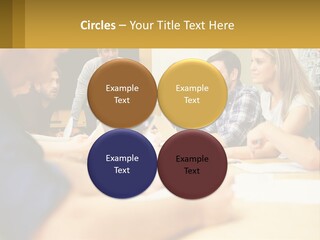 A Group Of People Sitting Around A Conference Table PowerPoint Template