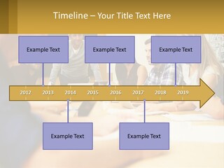 A Group Of People Sitting Around A Conference Table PowerPoint Template