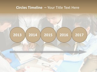 A Group Of People Sitting Around A Table With Papers PowerPoint Template