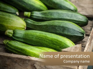 A Bunch Of Zucchini Sitting On Top Of A Wooden Box PowerPoint Template