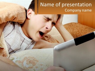 A Young Boy Laying In Bed Using A Laptop Computer PowerPoint Template