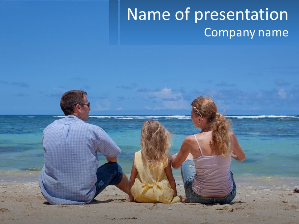 A Family Sitting On The Beach With The Ocean In The Background PowerPoint Template