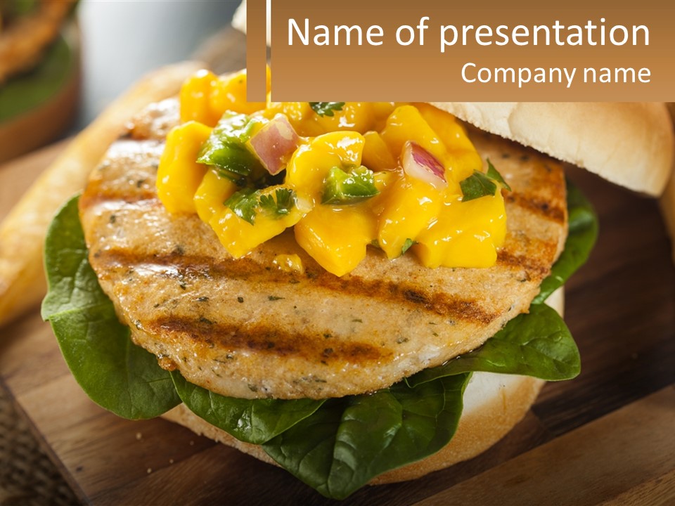 A Chicken Sandwich With Cheese And Lettuce On A Wooden Cutting Board PowerPoint Template