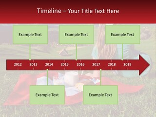 A Woman Sitting On Top Of A Blanket On Top Of A Lush Green Field PowerPoint Template