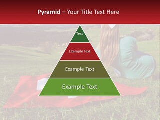 A Woman Sitting On Top Of A Blanket On Top Of A Lush Green Field PowerPoint Template