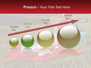 A Woman Sitting On Top Of A Blanket On Top Of A Lush Green Field PowerPoint Template
