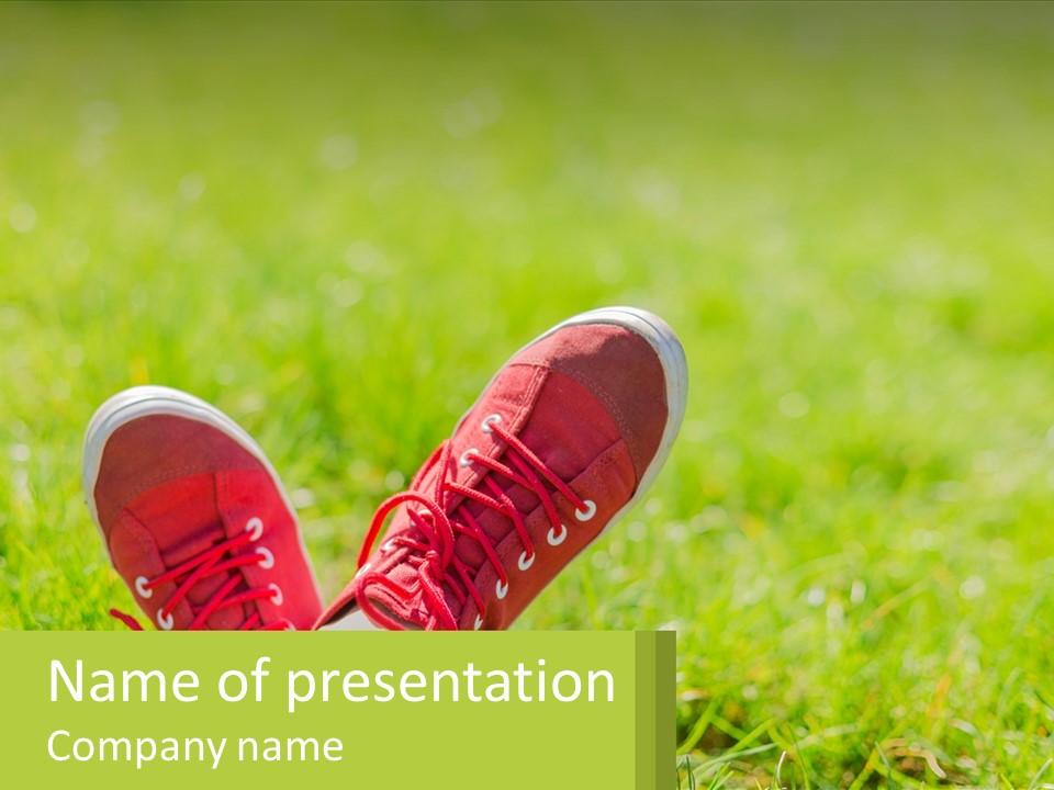 A Pair Of Red Shoes Sitting On Top Of A Lush Green Field PowerPoint Template