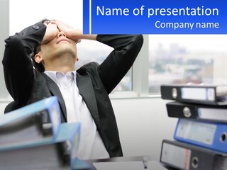 A Man Sitting At A Desk With His Head In His Hands PowerPoint Template