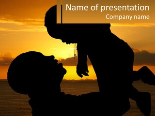 A Silhouette Of A Man Holding A Baby At Sunset PowerPoint Template
