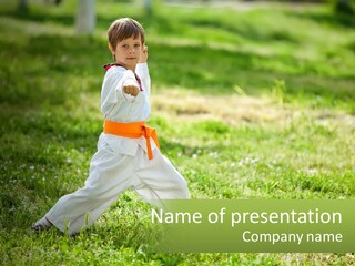 A Young Boy Is Practicing Karate In The Park PowerPoint Template