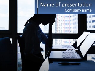A Man Sitting In Front Of A Laptop Computer PowerPoint Template