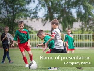 A Group Of Children Playing Soccer On A Field PowerPoint Template