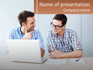 Two Men Sitting At A Table Looking At A Laptop PowerPoint Template