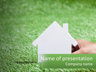 A Person Holding A Paper House In Their Hand PowerPoint Template