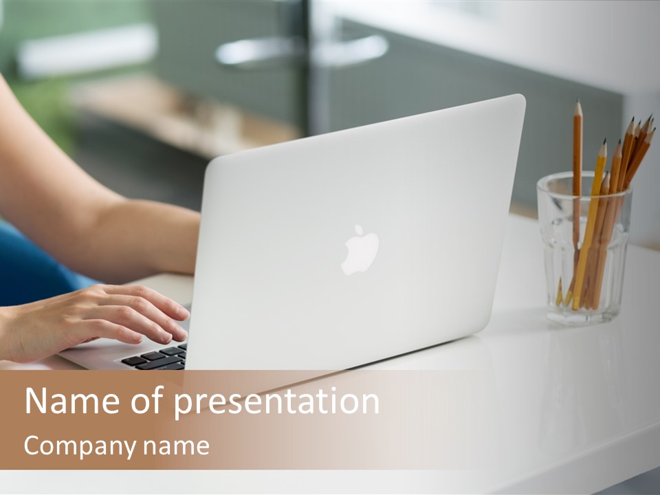 A Woman Using A Laptop Computer On A Desk PowerPoint Template