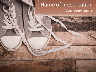 A Pair Of Gray Sneakers On A Wooden Floor PowerPoint Template