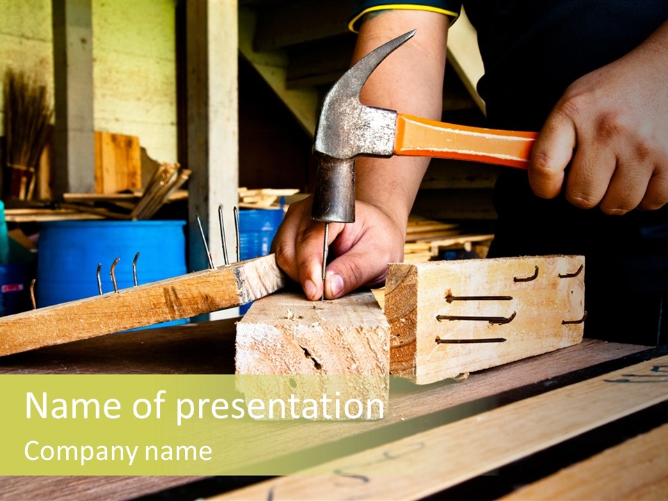 A Person Holding A Hammer Over A Block Of Wood PowerPoint Template
