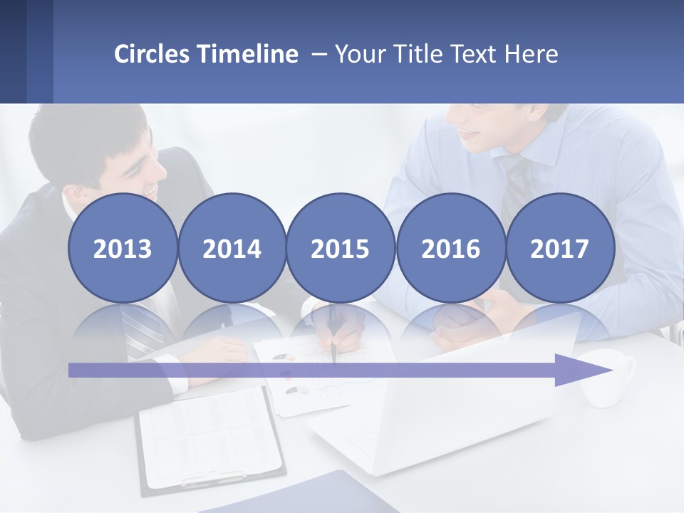 Two Men Sitting At A Table In Front Of A Laptop PowerPoint Template