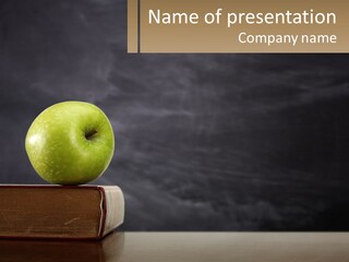 A Green Apple Sitting On Top Of A Book PowerPoint Template