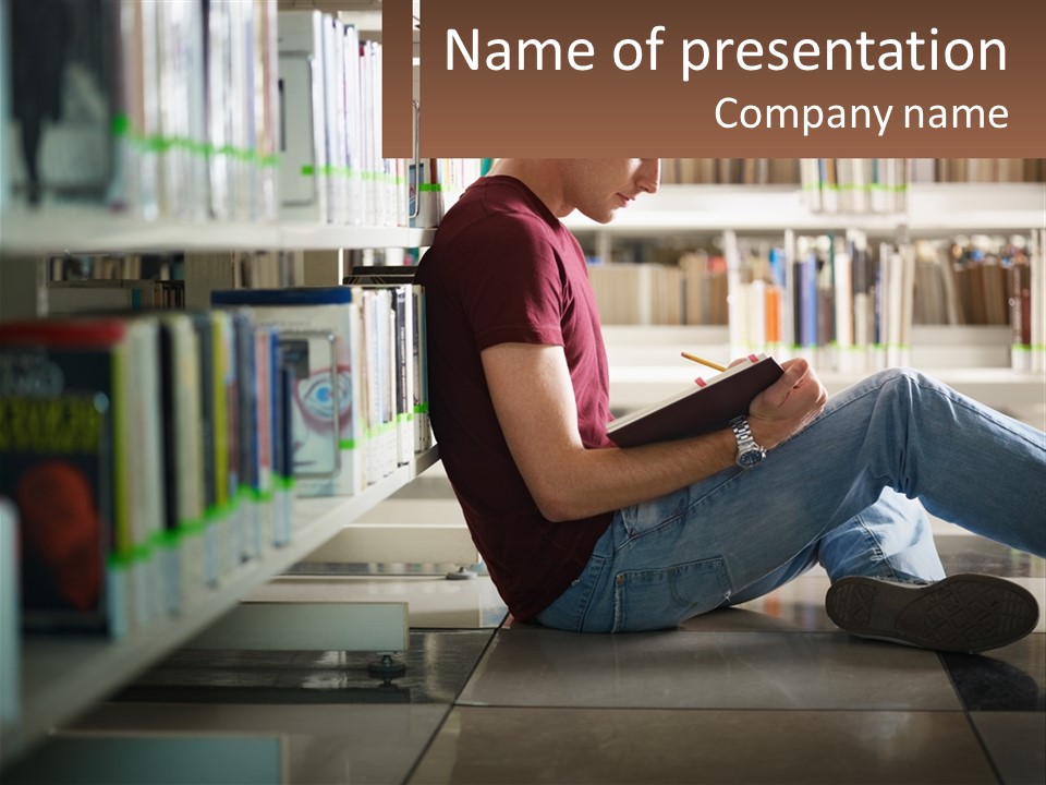 A Man Sitting On The Floor In A Library Reading A Book PowerPoint Template