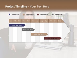 A Woman Sitting At A Desk In Front Of A Computer PowerPoint Template