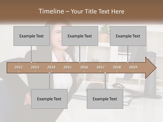 A Woman Sitting At A Desk In Front Of A Computer PowerPoint Template