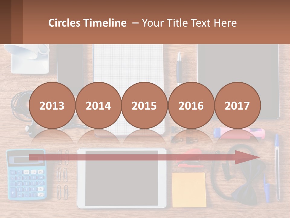 A Wooden Table Topped With Lots Of Office Supplies PowerPoint Template