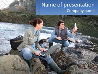 A Man And A Woman Sitting On Rocks With A Laptop PowerPoint Template