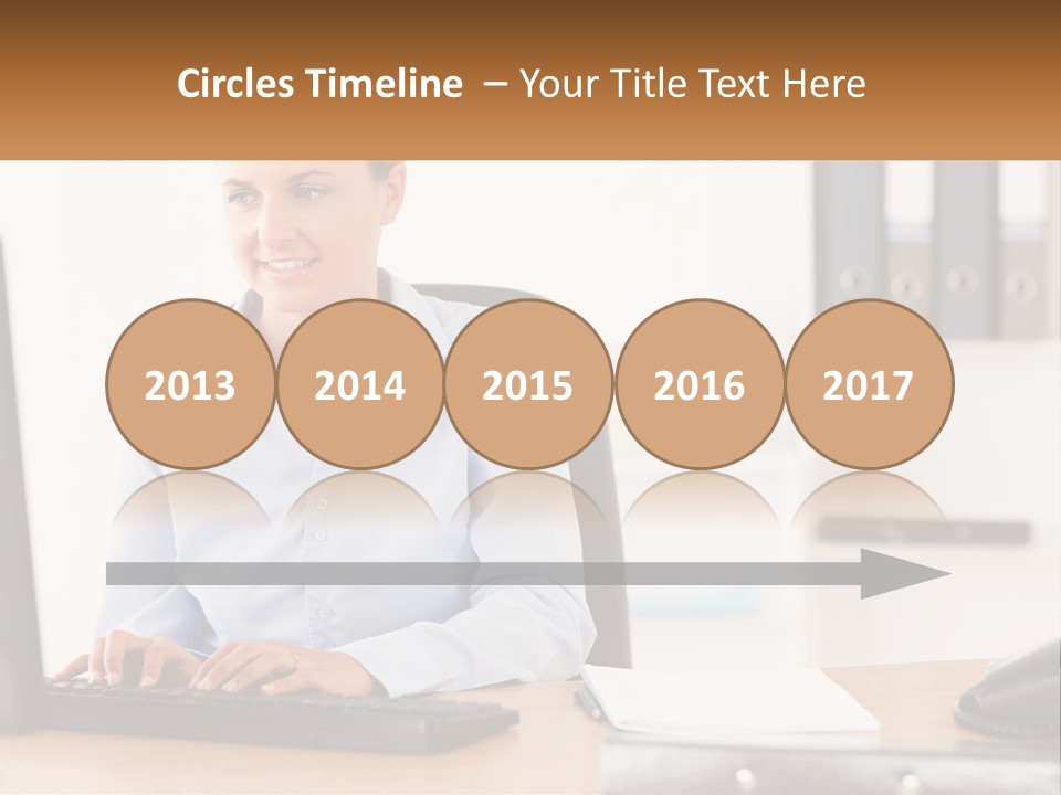 A Woman Sitting At A Desk In Front Of A Computer PowerPoint Template