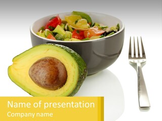 A Bowl Of Salad With An Avocado Next To A Fork PowerPoint Template