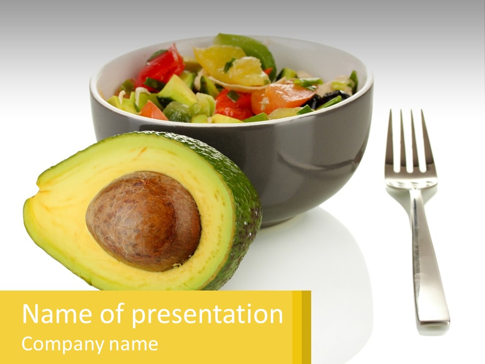 A Bowl Of Salad With An Avocado Next To A Fork PowerPoint Template
