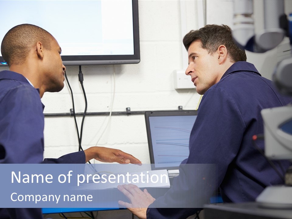 A Couple Of Men Sitting In Front Of A Laptop Computer PowerPoint Template