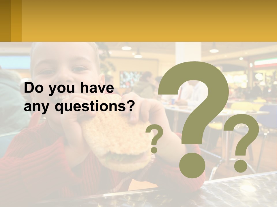 A Young Boy Eating A Sandwich In A Restaurant PowerPoint Template