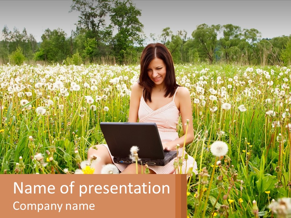 A Woman Sitting In A Field With A Laptop PowerPoint Template