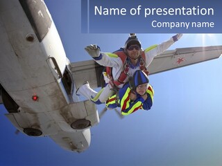 A Man In Safety Gear Is Hanging From The Wing Of A Plane PowerPoint Template