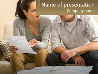 A Man And Woman Sitting On A Couch Looking At Papers PowerPoint Template